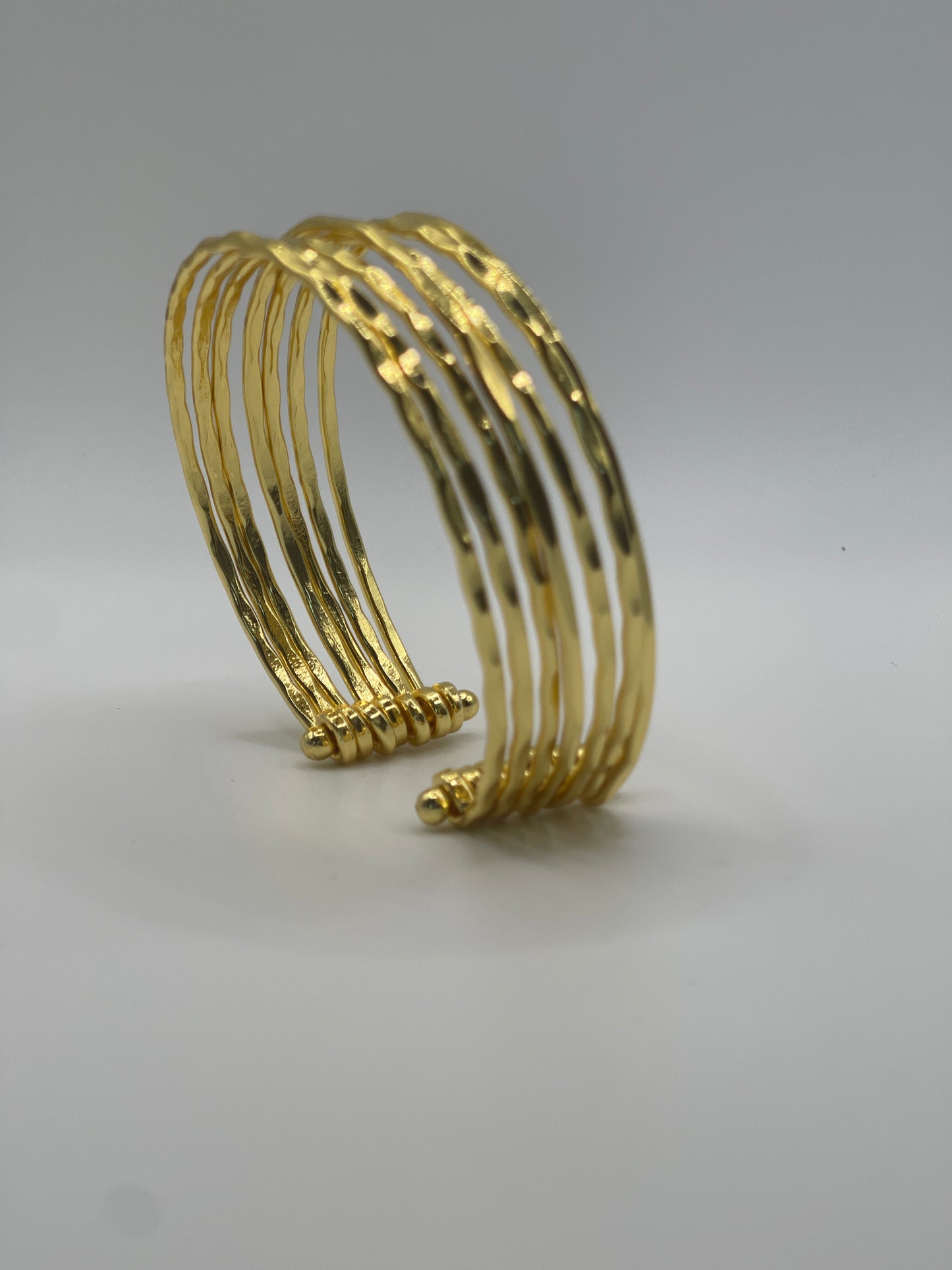 Sculptural multi-band gold cuff bracelet, elegant handmade jewelry.