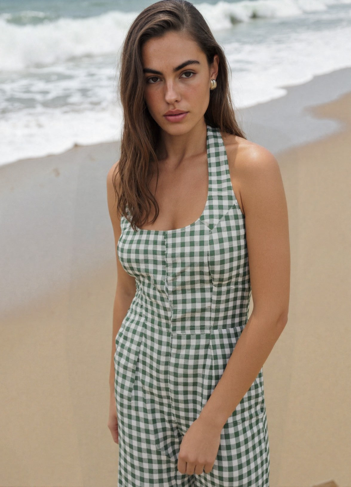 Model wearing the Sage Gingham Jumpsuit, a sleeveless, wide-leg green and white gingham jumpsuit, handmade by Kala Gaia.